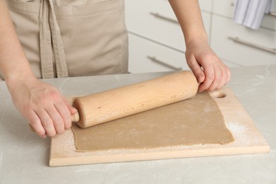 Photo of Woman making soba (buckwheat noodles) at light marble table indoors, closeup