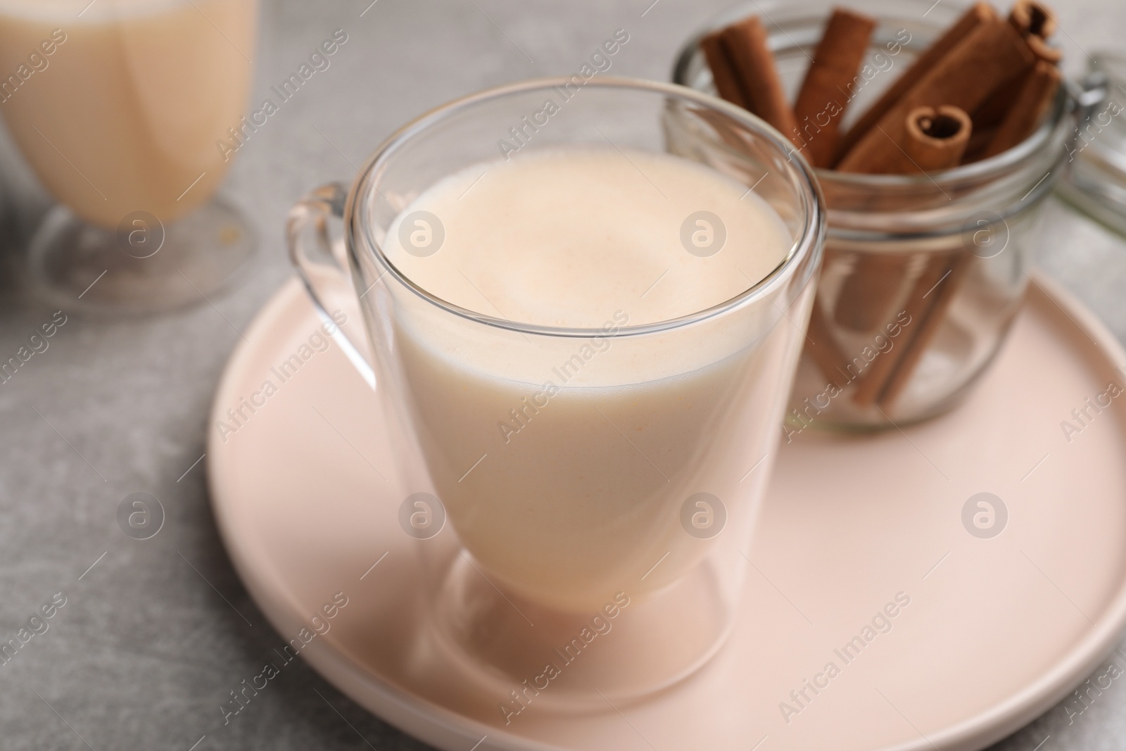 Photo of Delicious eggnog with cinnamon on light grey table