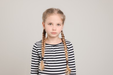 Photo of Little girl on light grey background. Children's bullying