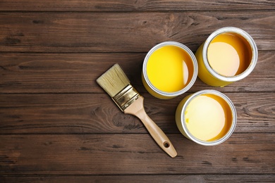 Flat lay composition with paint cans and brush on wooden background. Space for text