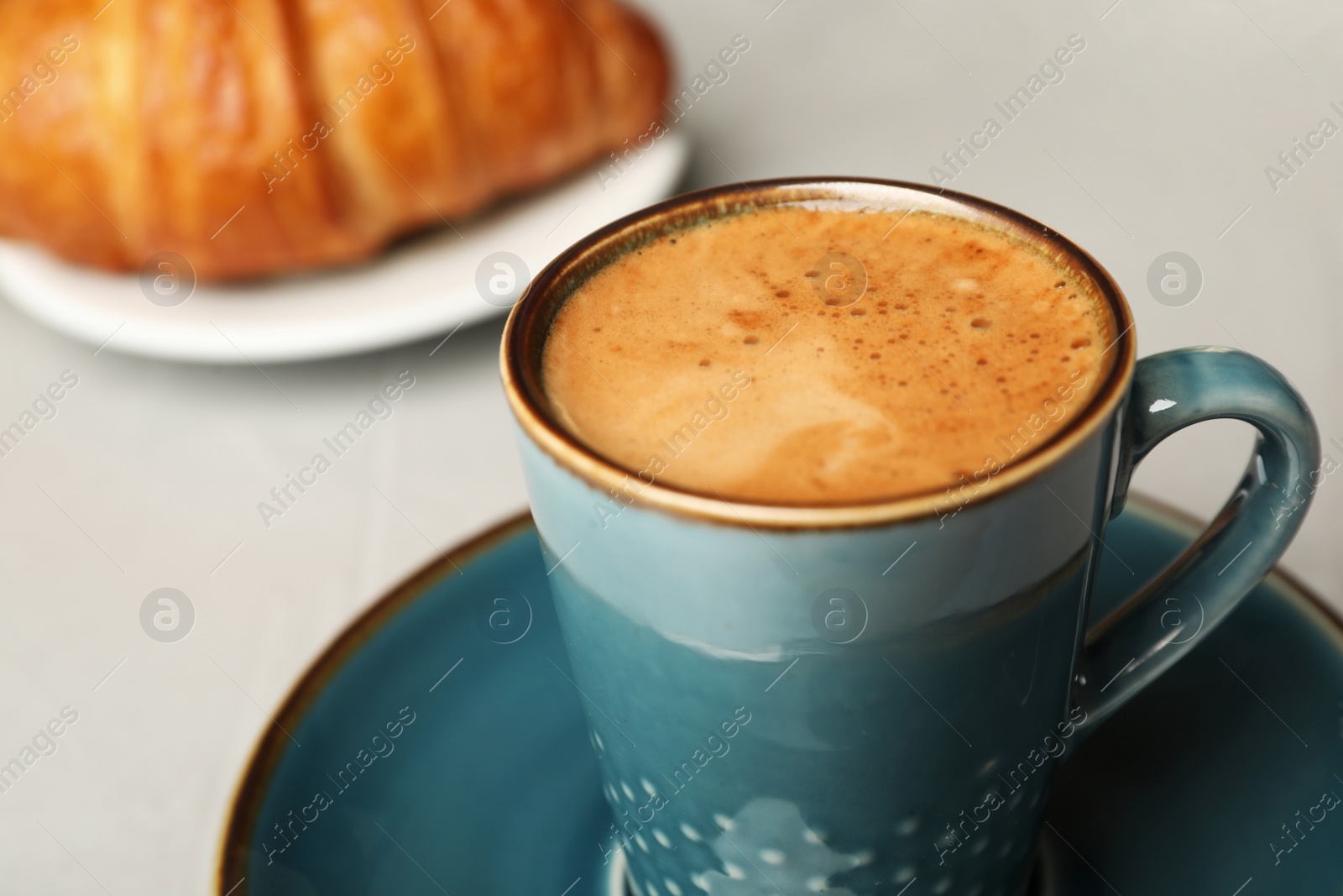 Photo of Cup of tasty aromatic coffee for breakfast on grey table, closeup