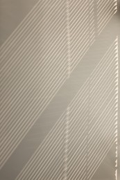 Photo of Shadow from window and blinds on beige wall indoors