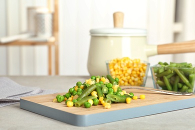 Photo of Board with mix of frozen vegetables on table