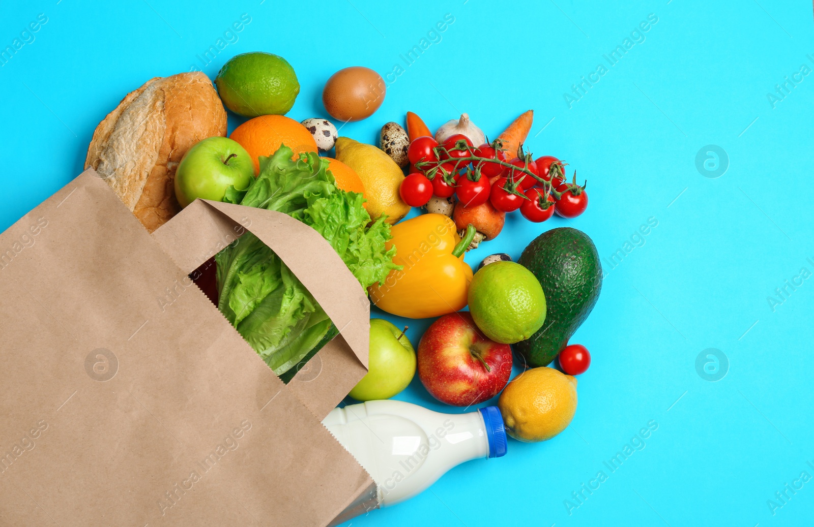 Photo of Paper bag with different groceries on light blue background, flat lay