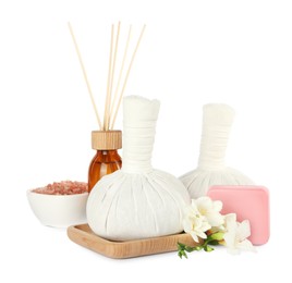 Photo of Herbal massage bags, soap, flowers, air reed diffuser and sea salt on white background. Spa procedure