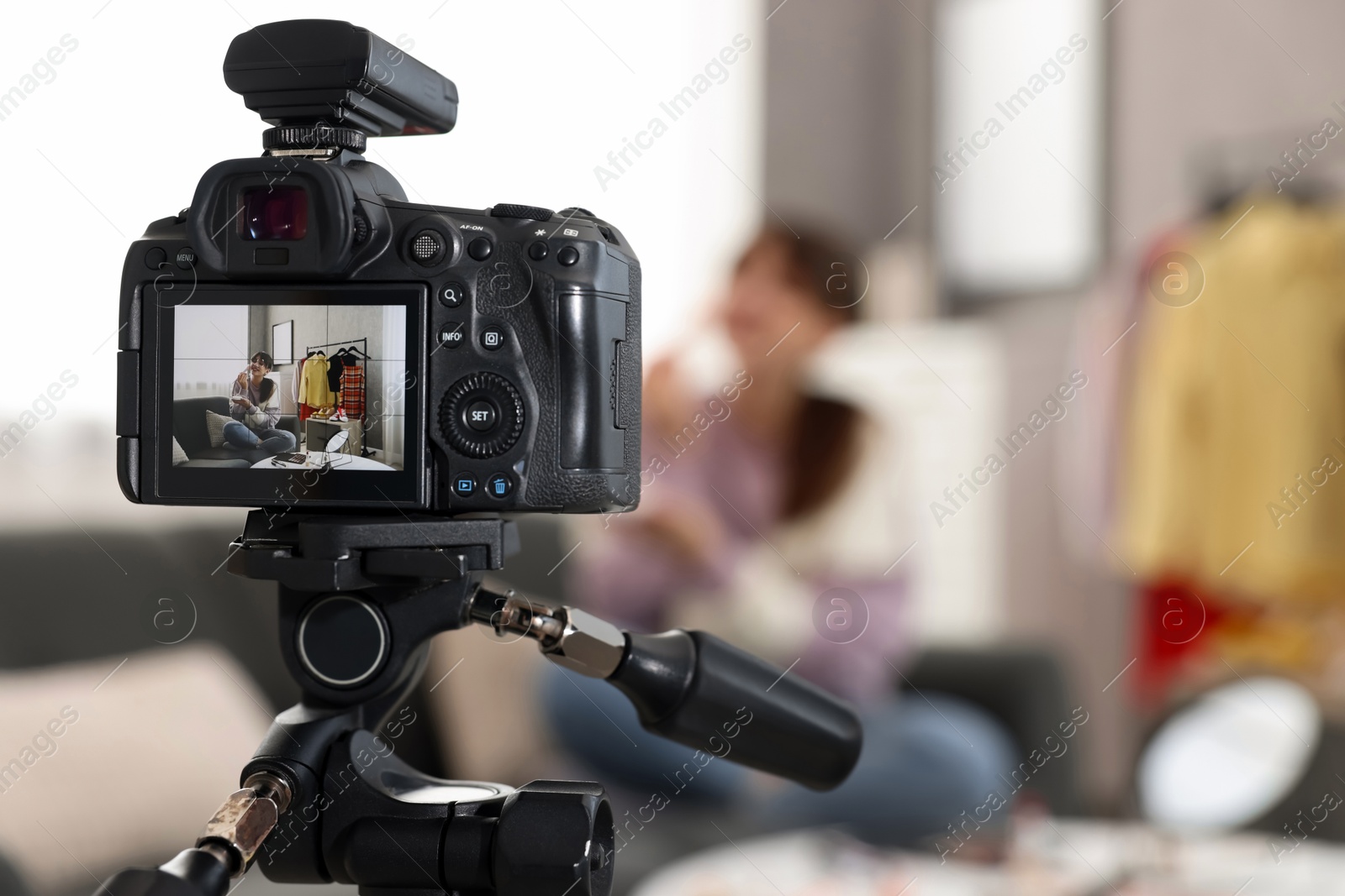 Photo of Beauty blogger recording makeup tutorial at home, focus on camera