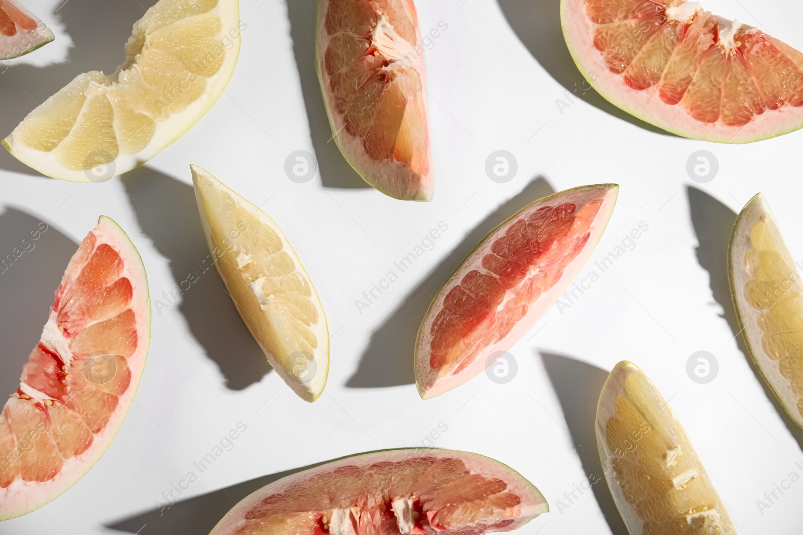 Photo of Slices of different ripe pomelos on white background, flat lay