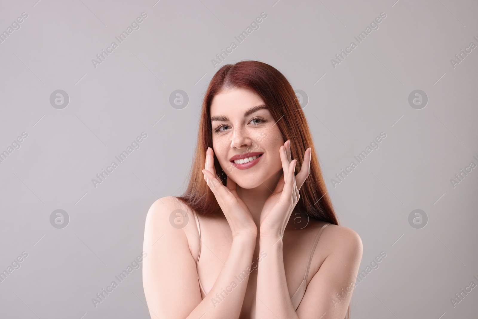 Photo of Portrait of smiling woman on grey background