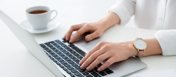 Image of Young woman working on computer at table in office, closeup. Banner design