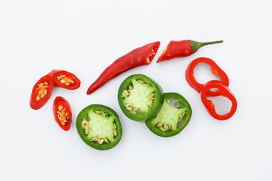Photo of Cut hot chili peppers on white background, flat lay