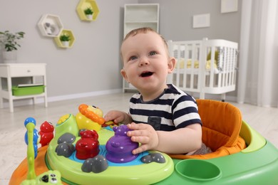 Photo of Portrait of cute baby with toy walker at home. Learning to walk