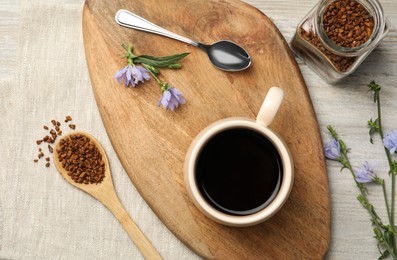 Photo of Flat lay composition with delicious chicory drink, granules and flowers on table