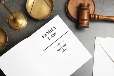 Flat lay composition with book, gavel and scales of justice on grey background. Family law concept