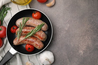 Frying pan with tasty homemade sausages, rosemary and tomatoes on brown textured table, flat lay. Space for text