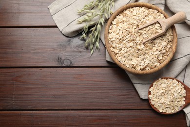 Oatmeal and branches with florets on wooden table, flat lay. Space for text