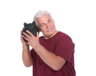 Mature man with piggy bank on white background