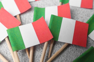 Photo of Small paper flags of Italy on grey textured table, closeup
