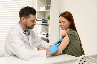 Doctor giving hepatitis vaccine to patient in clinic