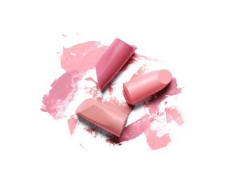 Photo of Different lipsticks and smears on white background, top view