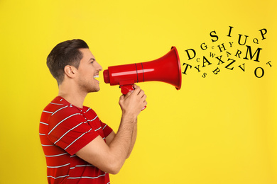 Image of Handsome man with megaphone and letters on yellow background. Speech therapy concept