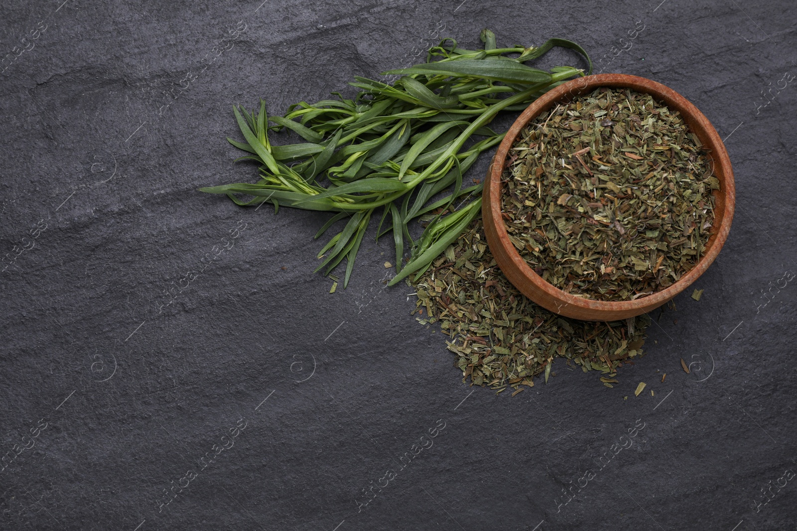 Photo of Dry and fresh tarragon on black textured table, flat lay. Space for text