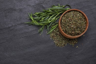 Photo of Dry and fresh tarragon on black textured table, flat lay. Space for text