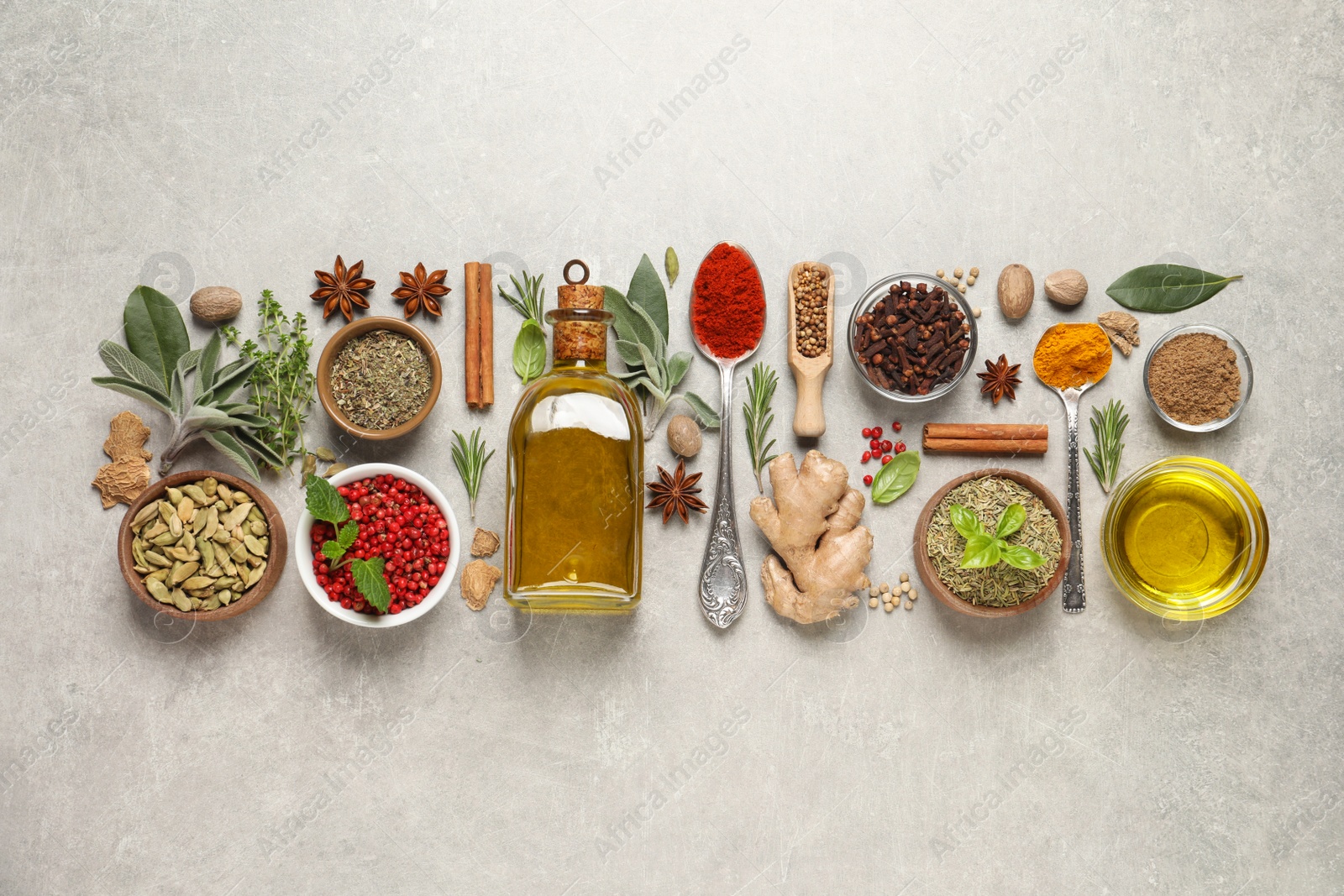 Photo of Different herbs and spices on grey table, flat lay