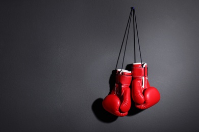 Pair of boxing gloves on grey background, space for text