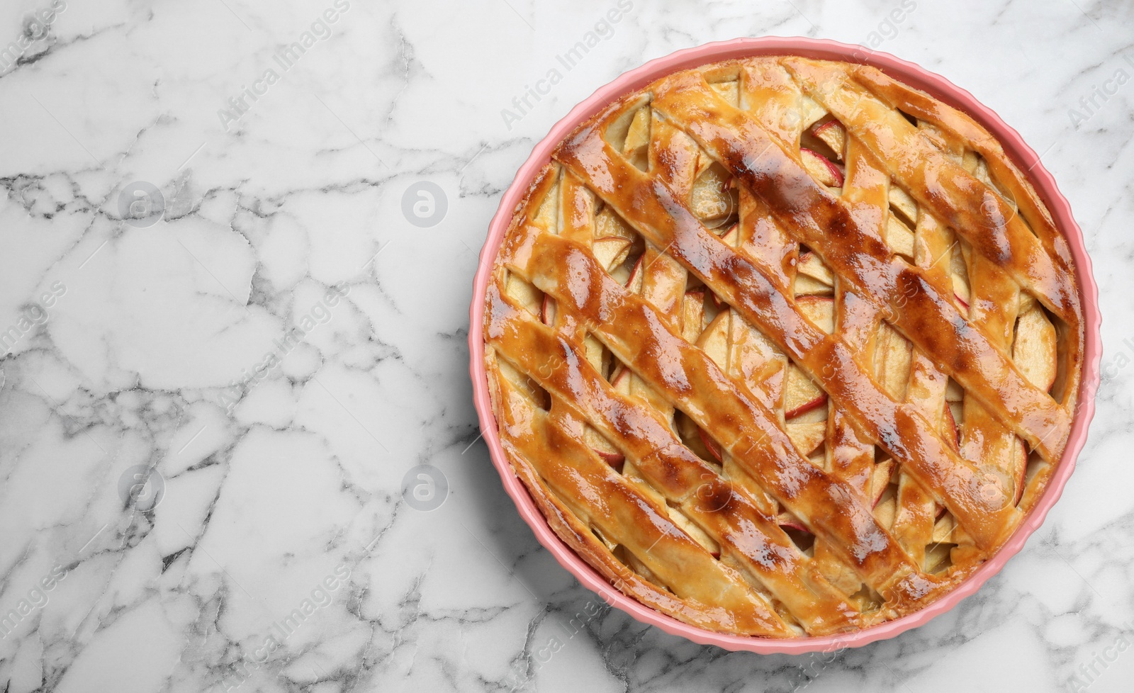 Photo of Fresh traditional apple pie on white marble table, top view. Space for text