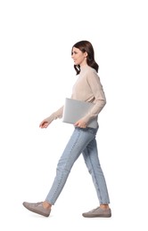 Happy young woman with laptop walking on white background