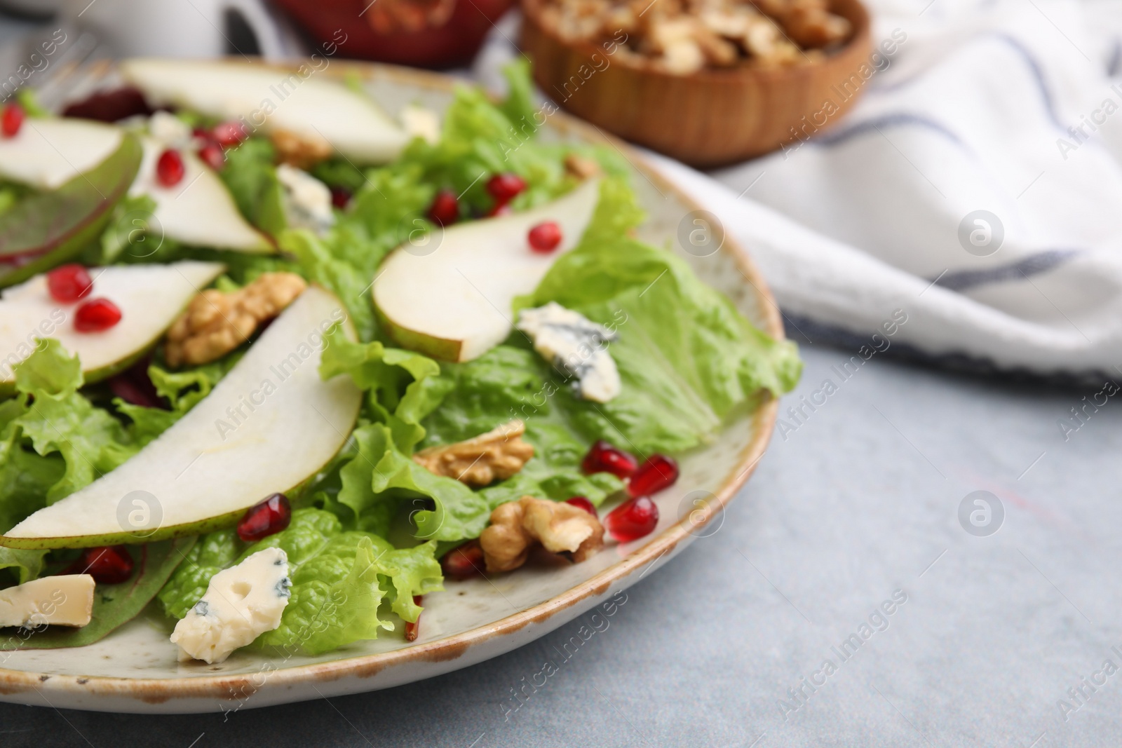 Photo of Delicious pear salad on grey textured table, closeup. Space for text