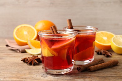 Photo of Aromatic punch drink and ingredients on wooden table