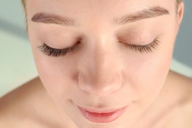 Photo of Young woman with beautiful eyelashes, closeup. Before and after extension procedure