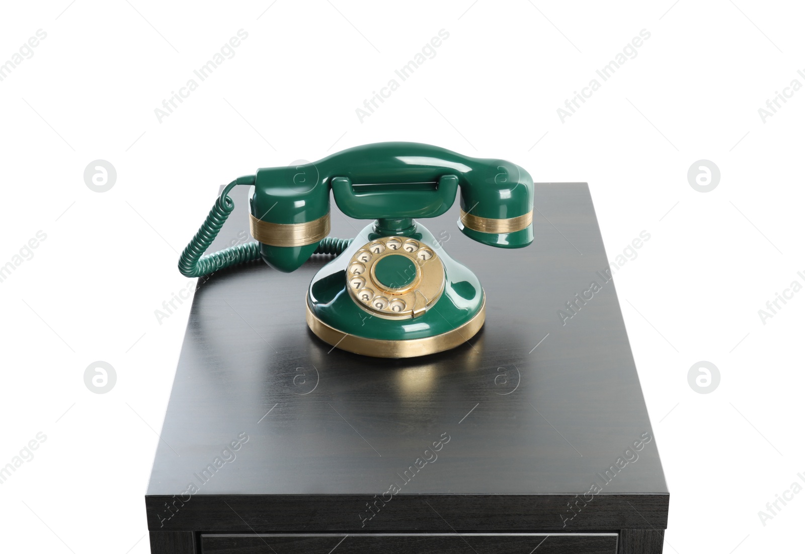 Photo of Green vintage corded phone on small black table against white background