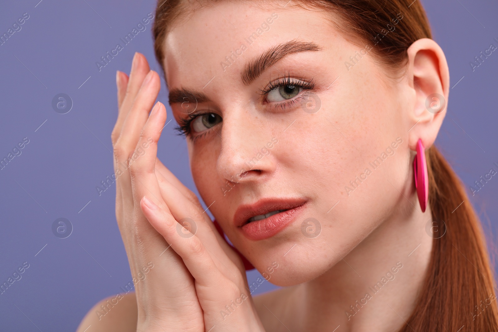 Photo of Portrait of beautiful woman with freckles on purple background, closeup