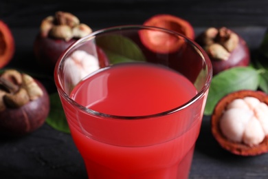 Delicious fresh mangosteen juice in glass on table, closeup