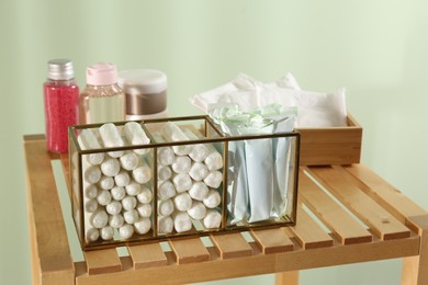 Organizer with many tampons on wooden table against light green background. Menstrual hygienic product