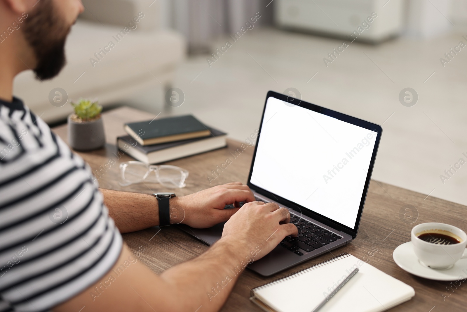 Photo of Young man watching webinar at table in room, closeup