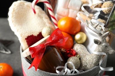 Basket with Christmas gift set on table, closeup