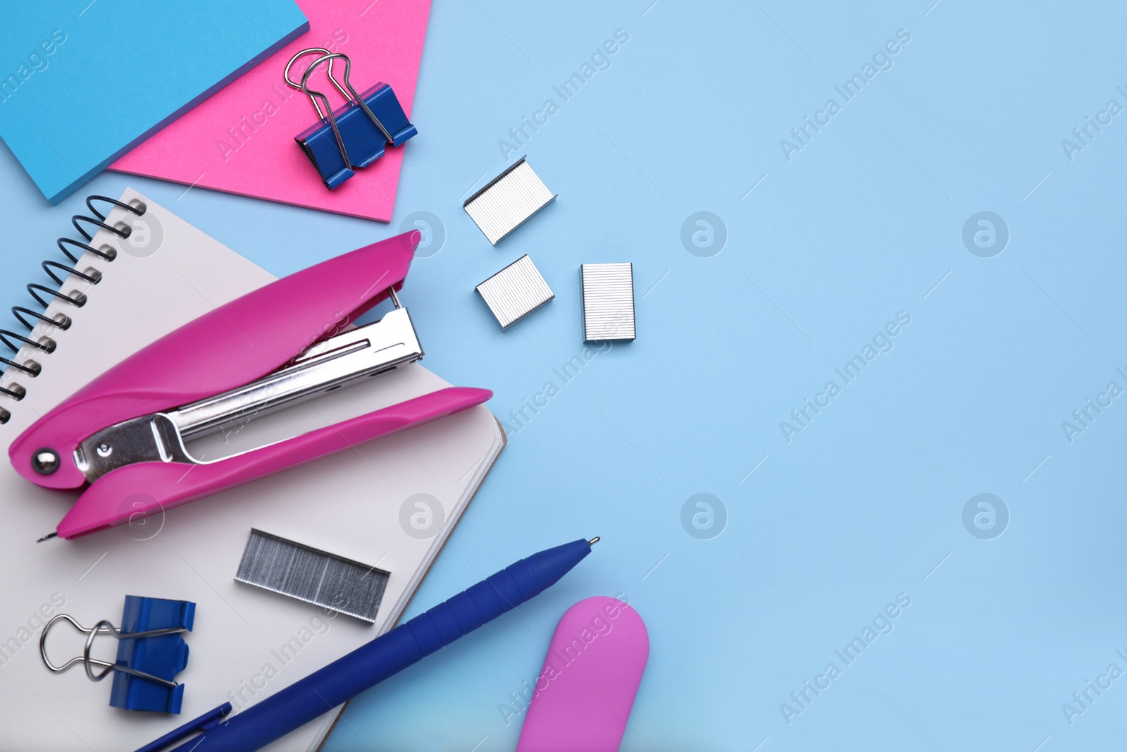 Photo of Flat lay composition with new stapler on light blue background, space for text