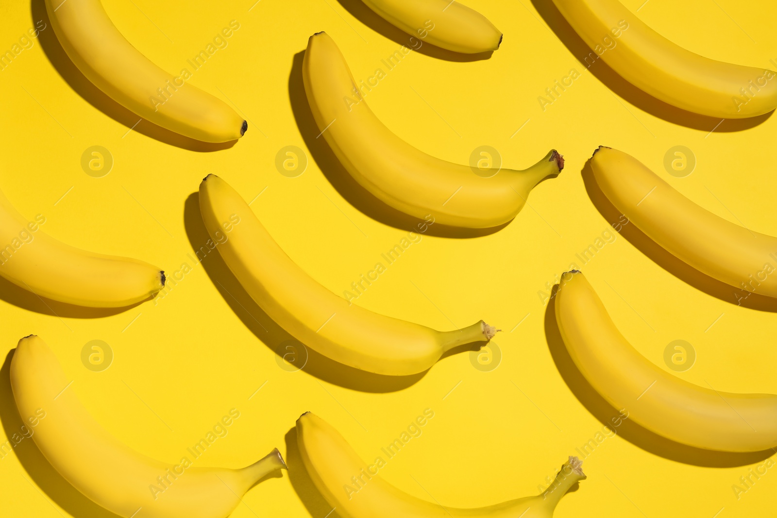 Photo of Ripe sweet bananas on yellow background, flat lay