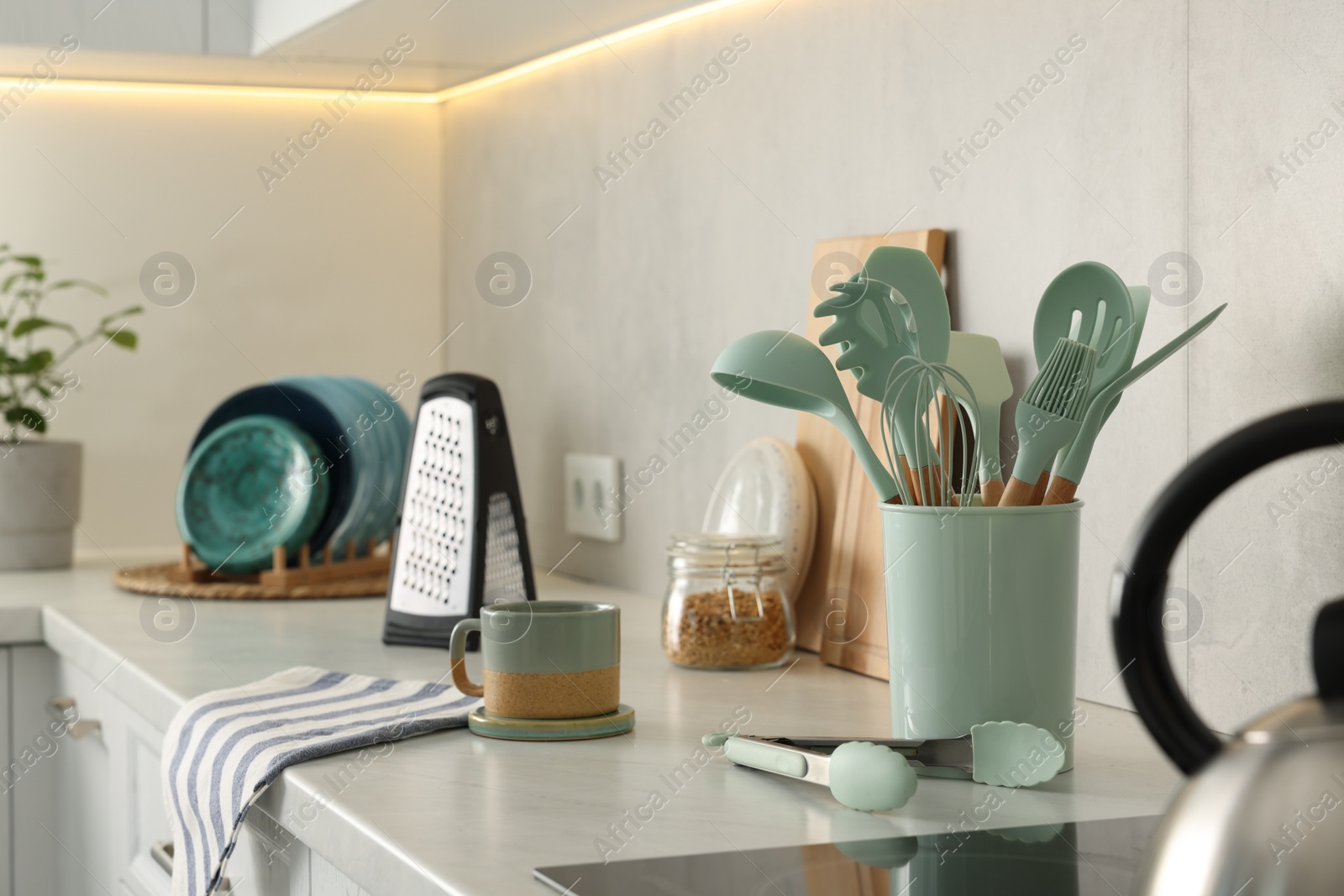 Photo of Set of different utensils and dishes on countertop in kitchen