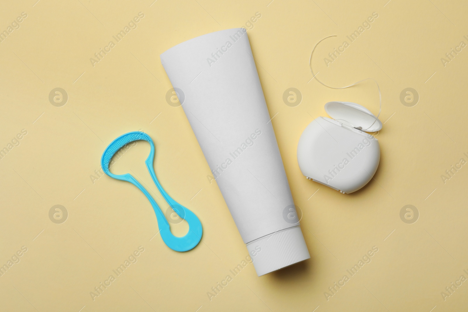 Photo of Tongue cleaner, tooth paste and dental floss on color background, flat lay