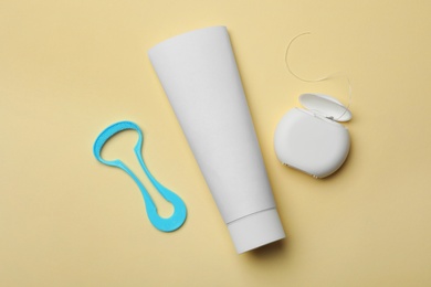 Photo of Tongue cleaner, tooth paste and dental floss on color background, flat lay