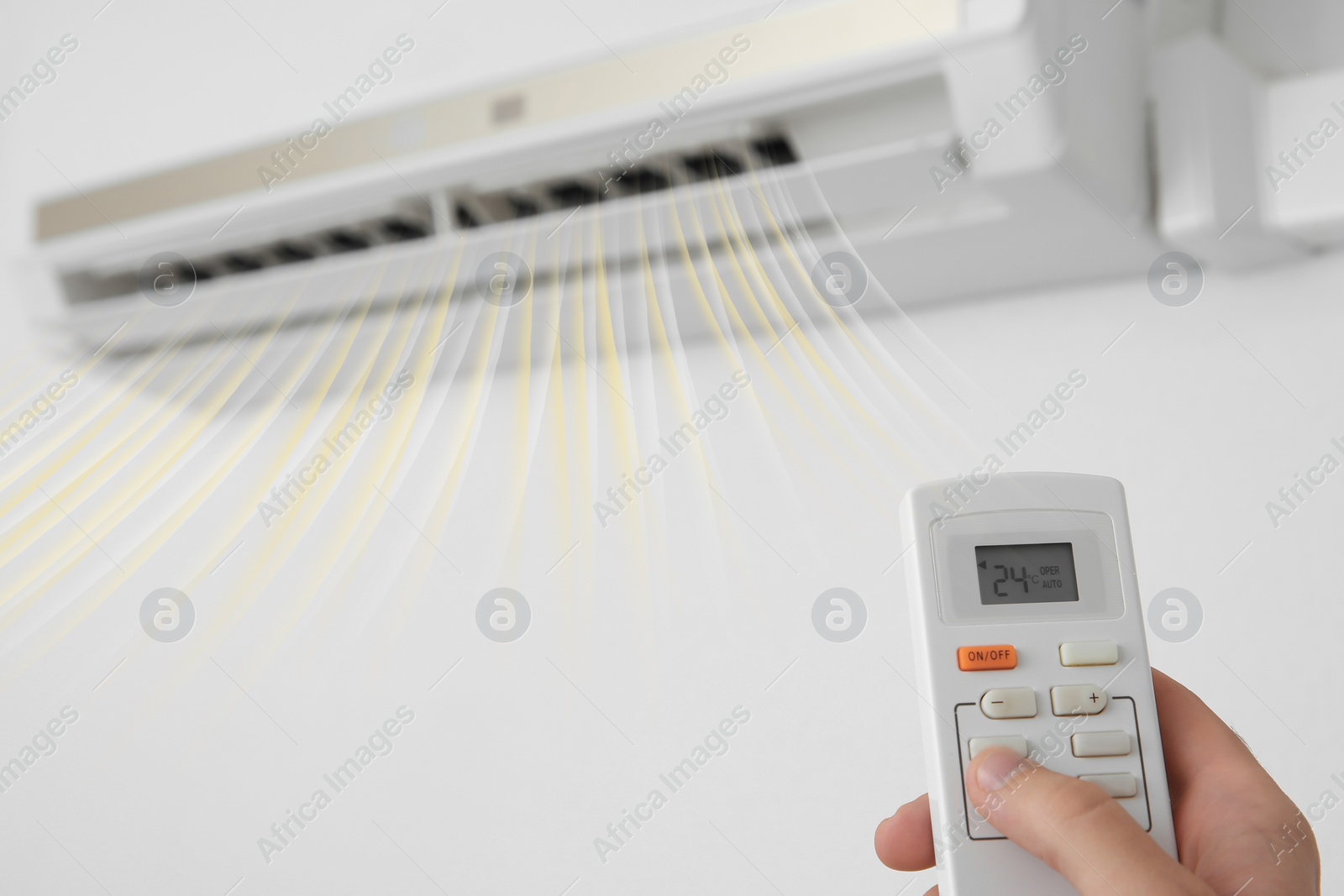 Image of Man operating air conditioner with remote control indoors, closeup 