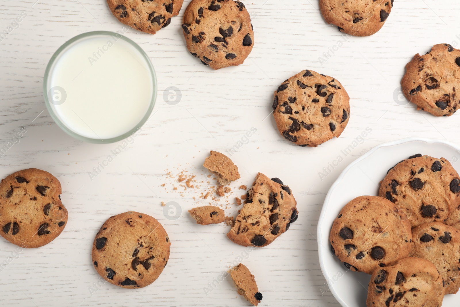 Photo of Flat lay composition with chocolate cookies and glass of milk on light background