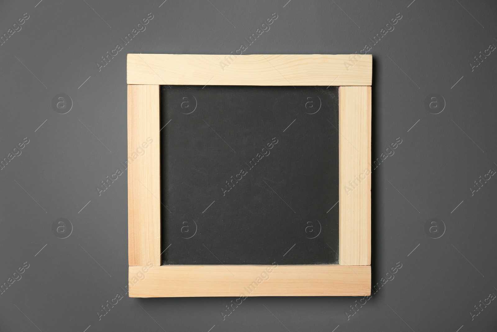 Photo of Small clean chalkboard hanging on grey wall