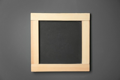 Small clean chalkboard hanging on grey wall