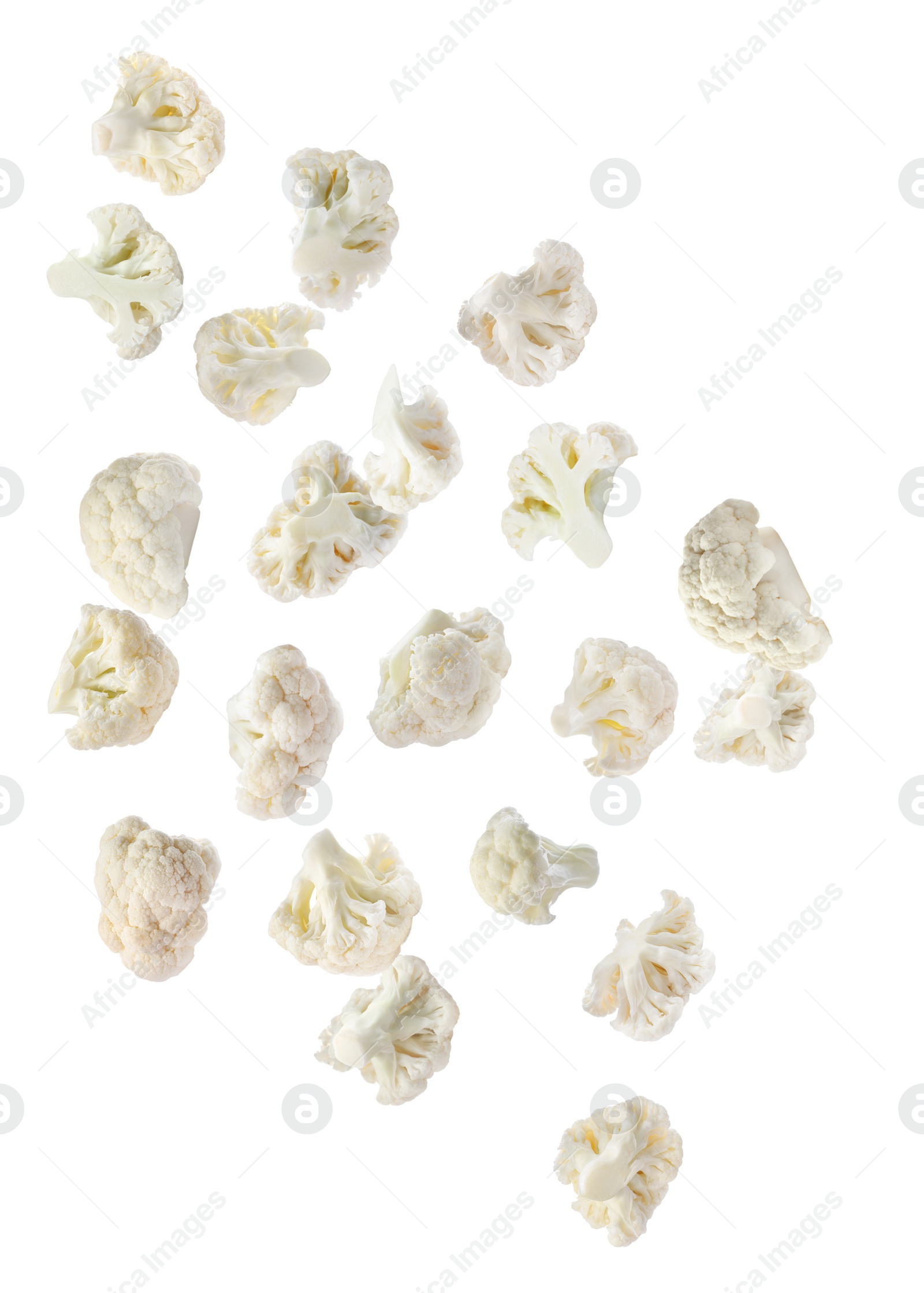 Image of Many fresh cauliflower florets falling on white background