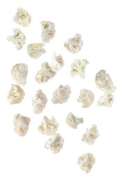 Many fresh cauliflower florets falling on white background